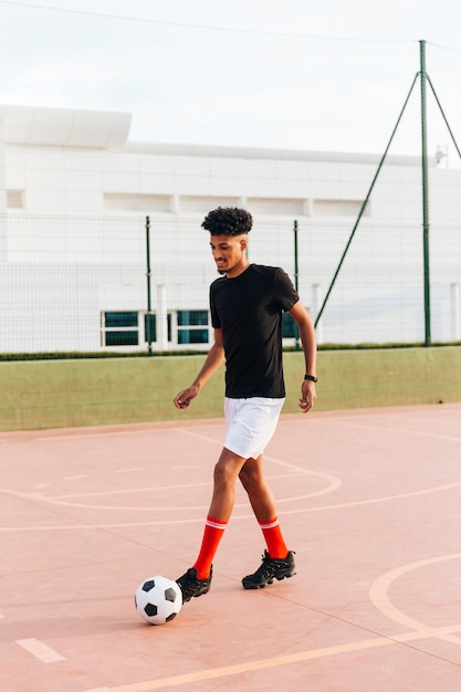 Football player kicking ball at sports ground