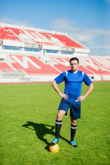 Football player posing in stadium