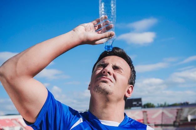 Football player refreshing with water
