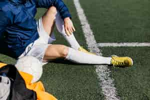 Free photo football player sitting on field