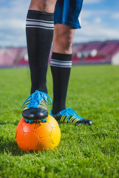 Football player in stadium with foot on ball