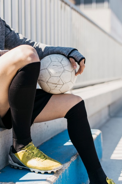 Free photo football player with ball on bench