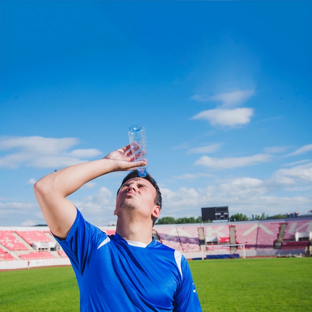 Football player with water in stadium