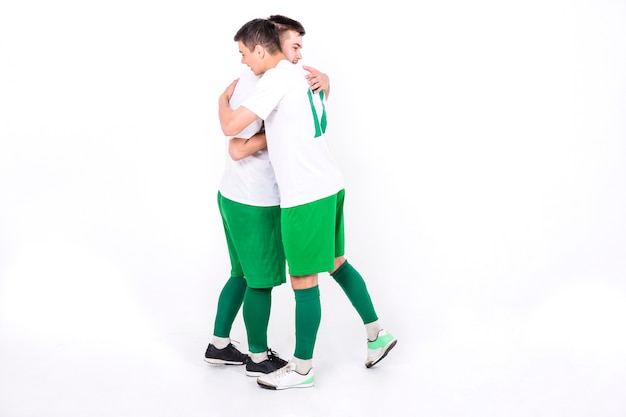 勝利の後に抱き合っているサッカー選手