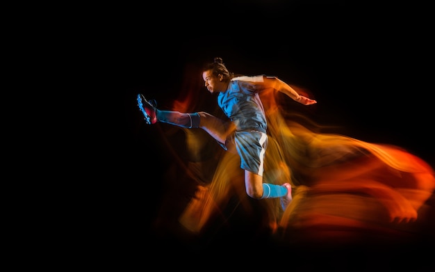 Football or soccer player on black studio