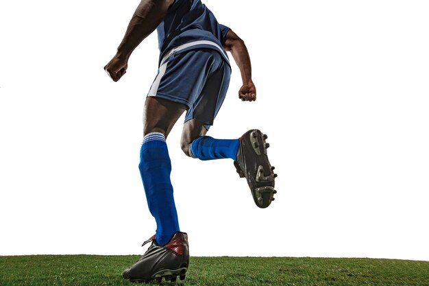 Football or soccer player on white wall with grass. Yovercoming. Wide angle.