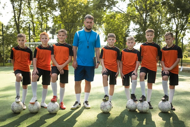 Тренер по футболу обучает своих учеников