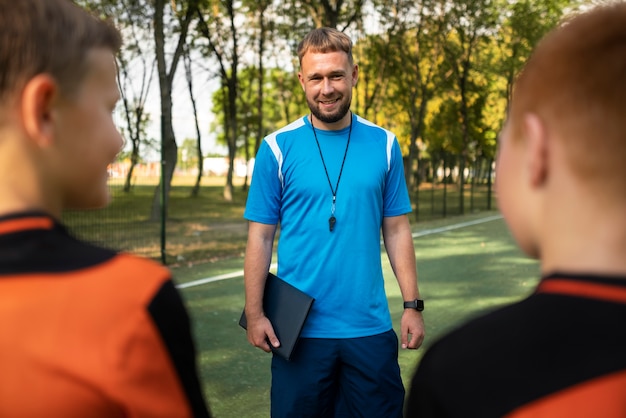 Foto gratuita allenatore di calcio che insegna ai suoi alunni