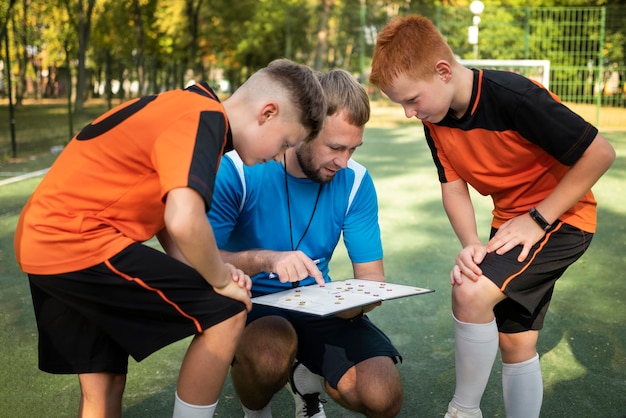 Allenatore di calcio che insegna ai suoi alunni