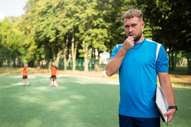 Foto gratuita allenatore di calcio che insegna ai suoi alunni