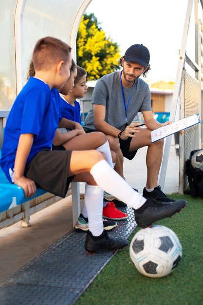 子供たちにフルショットを教えるサッカートレーナー