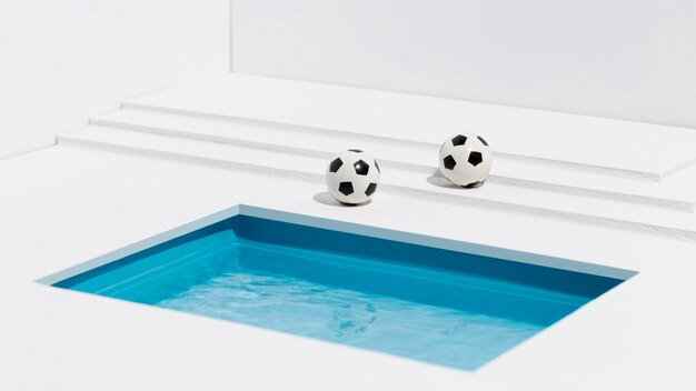 Footballs next to small swimming pool