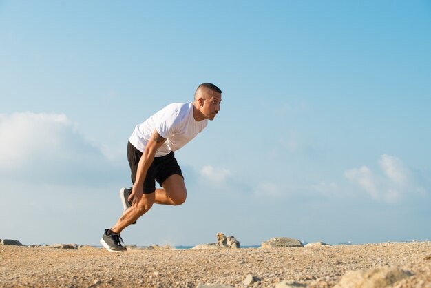 Силовой молодой спортсмен, начинающий бегать на открытом воздухе