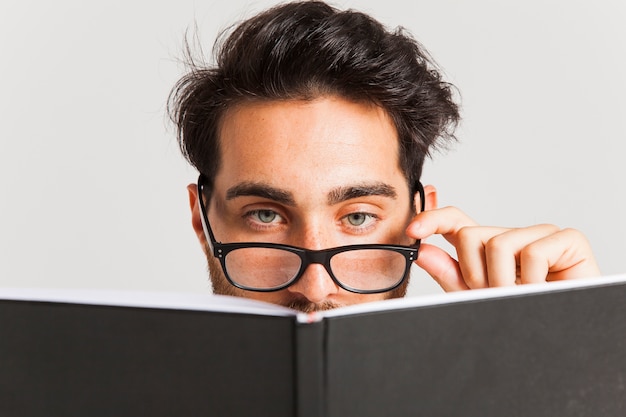 Бесплатное фото Человек переднего плана с книгой и очками