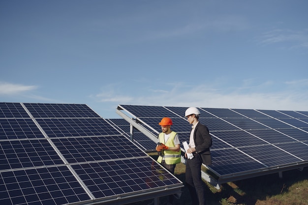 Foto gratuita caporeparto e uomo d'affari alla stazione di energia solare.