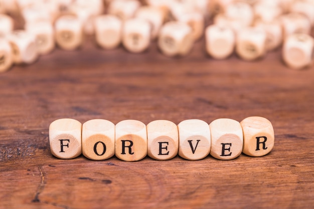 Free photo forever word on wooden table