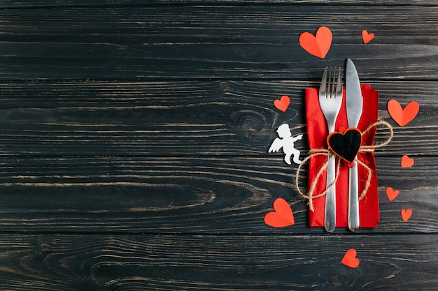 Free photo fork and knife on napkin with paper hearts