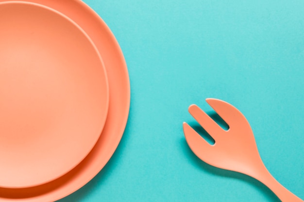 Fork and plates on blue background