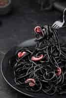 Бесплатное фото Вилка с черными спагетти и кальмарами