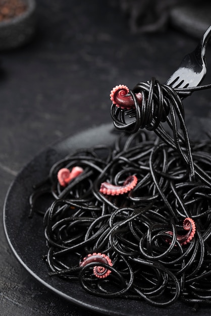 Free photo fork with black spaghetti and squid