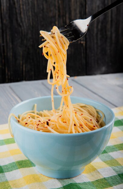 Fork with spaghetti pasta with chili flakes around