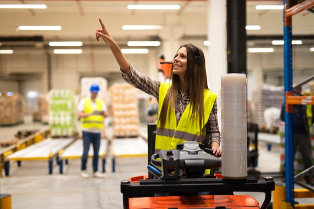 Forklift operator looking for an empty space on a shelf in warehouse distribution center