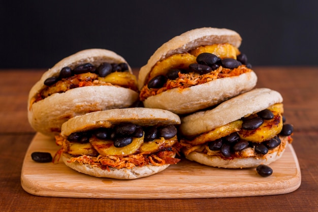 Four arepas with delicious filling on chopping board