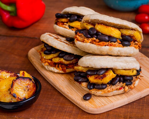 Four arepas with tasty filling on chopping board