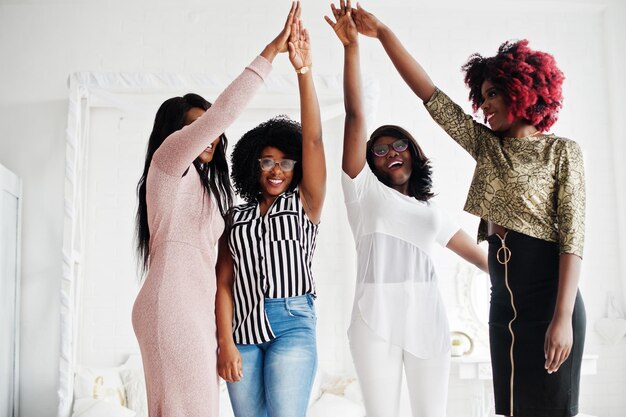 Four best friends Young adrican women having fun and spend time together stacking hands and then up