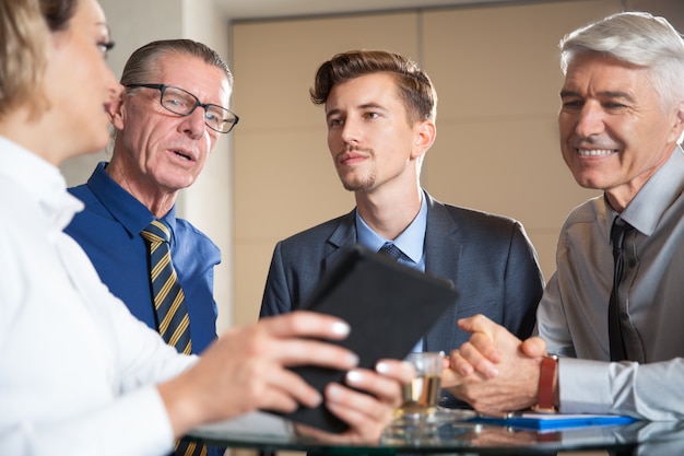 Four Business People Using Tablet in Cafe