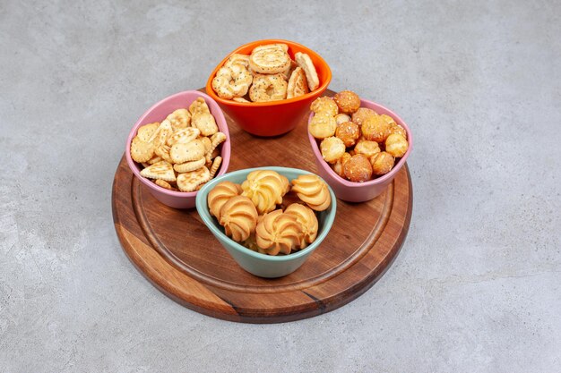 바삭한 비스킷과 대리석 배경에 나무 보드에 쿠키 칩의 4 개의 다채로운 그릇. 고품질 사진