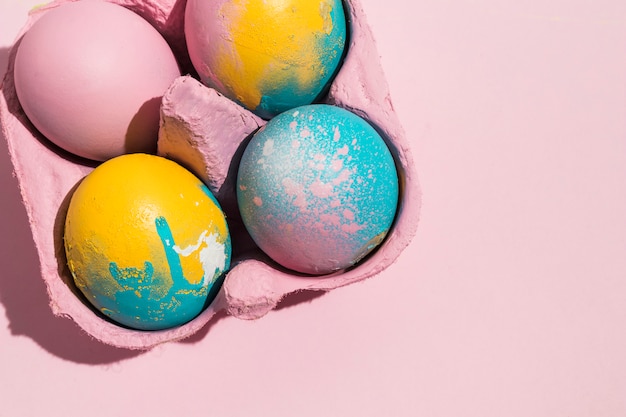 Four colorful Easter eggs in rack on table