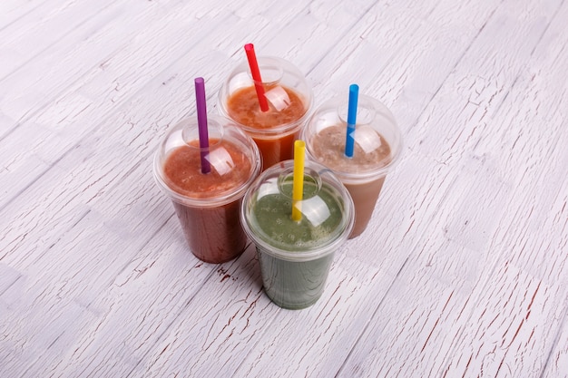 Четыре красочных, полезных и здоровых коктейля в пластиковых стаканчиках