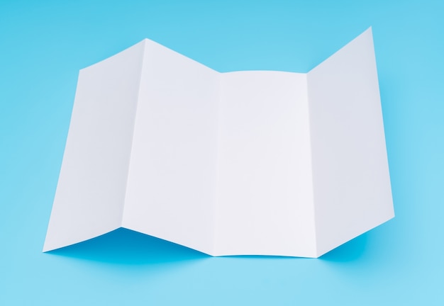 Four- fold white template paper on blue background .