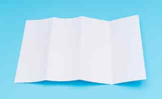 Free photo four- fold white template paper on blue background .