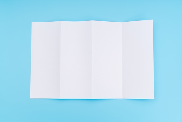 Four- fold white template paper on blue background .