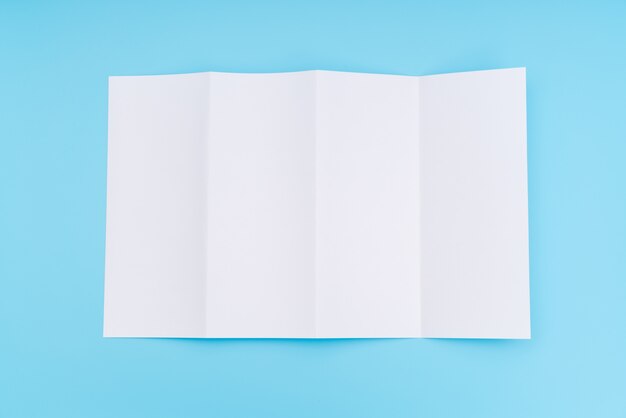 Four- fold white template paper on blue background .