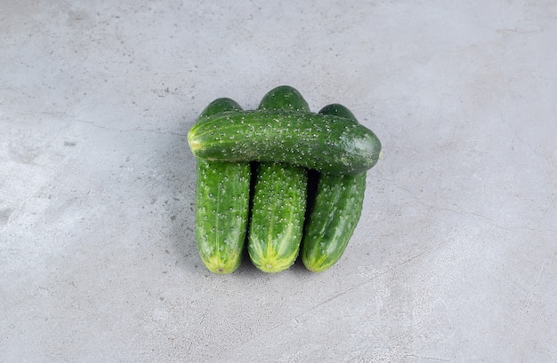 Four fresh cucumbers isolated on a gray background. High quality photo