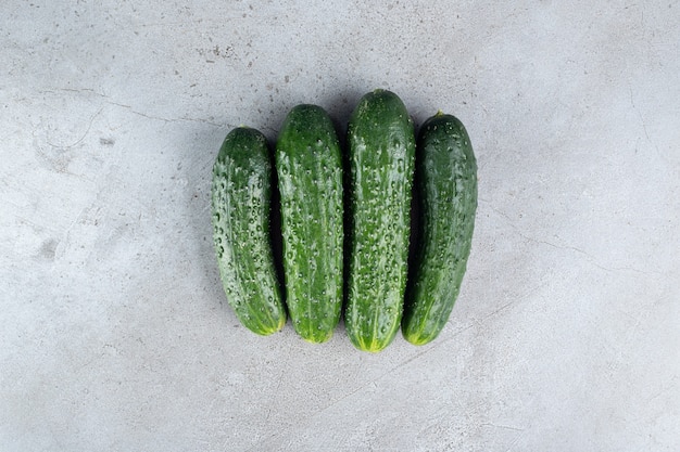 Four fresh cucumbers isolated on a gray background. High quality photo