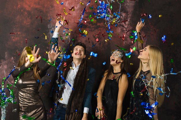 Four friends celebrating 2018 with confetti