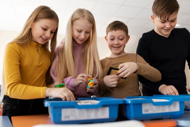 Four kids using electronic parts to build a robot