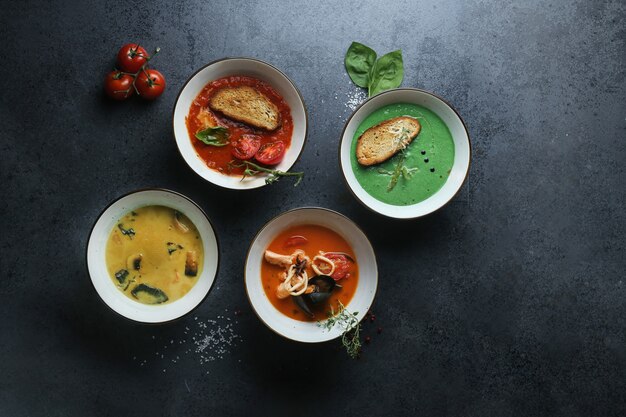 Four kinds of cream soups made of tomatoes, mushrooms, seafood, and basil