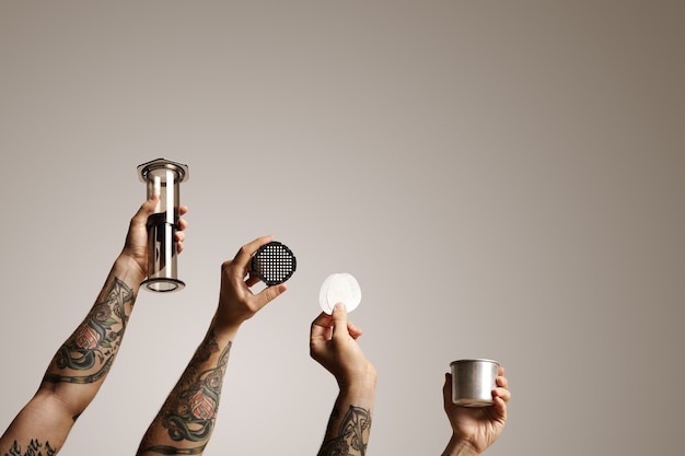 Foto gratuita quattro mani di uomo con aeropress e pezzi di ricambio isolati su bianco commerciale di fermentazione alternativa del caffè