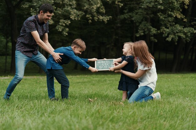 Семья из четырех человек веселится во время игры в парке