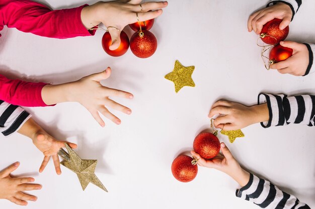 Four pairs of hands and christmas balls