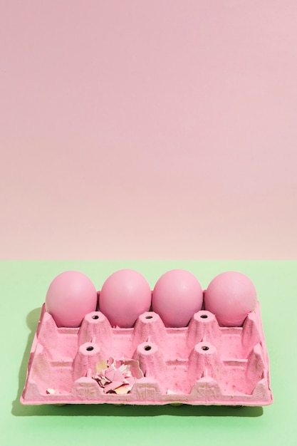 Four pink Easter eggs in big rack on green table