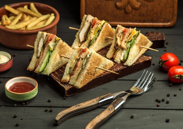 Four small chicken club sandwich portions on bamboo skewers