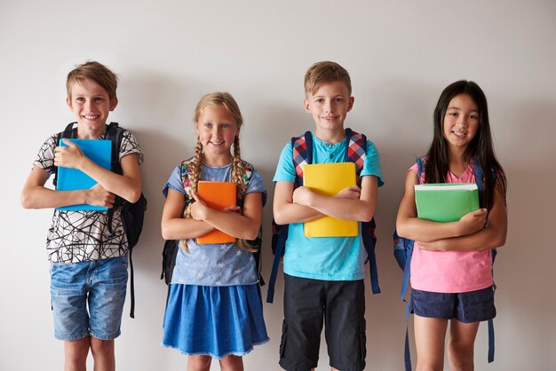 Four smiley kids holding books