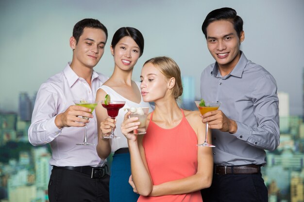 Four Smiling People with Cocktails Having Fun