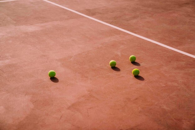 Four tennis balls on court
